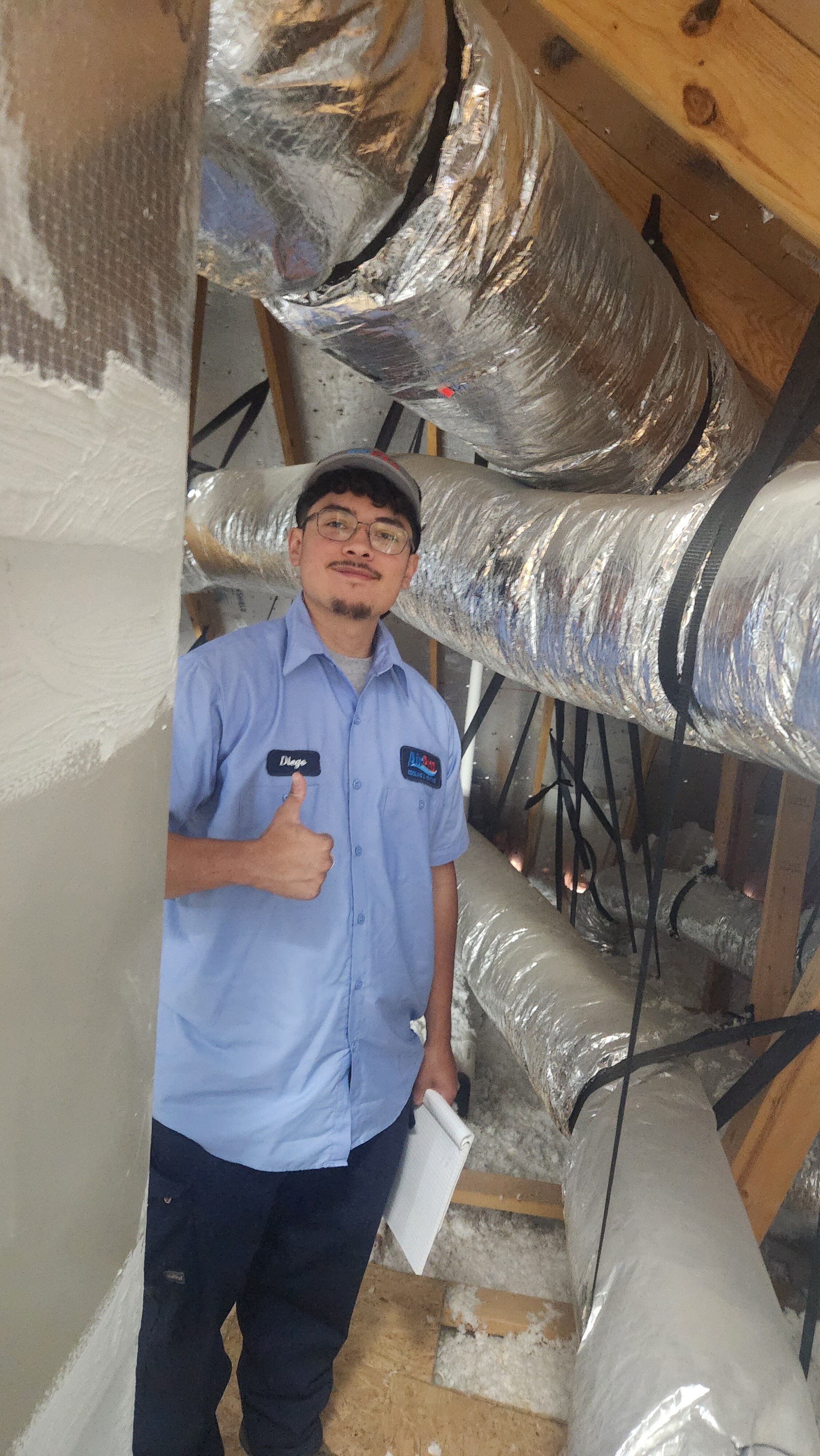 An AirPro technician inspecting ductwork and blown-in insulation in a San Antonio attic