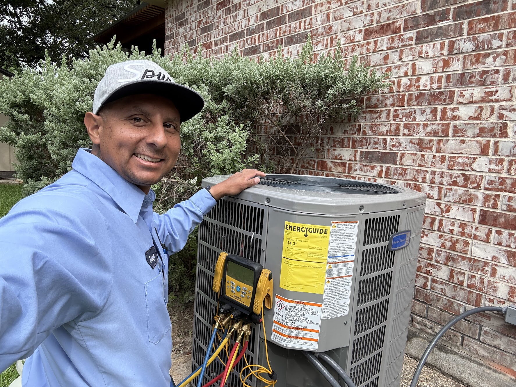 AirPro technician on a service call next to an AC condenser unit
