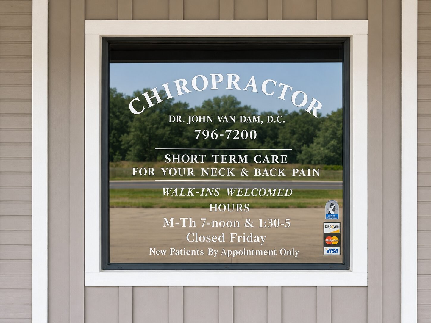 The front window at Bandera Chiropractic, lettered Chiropractor, Dr. John Van Dam, D.C., 796-7200, walk-ins welcomed, new patients by appointment only