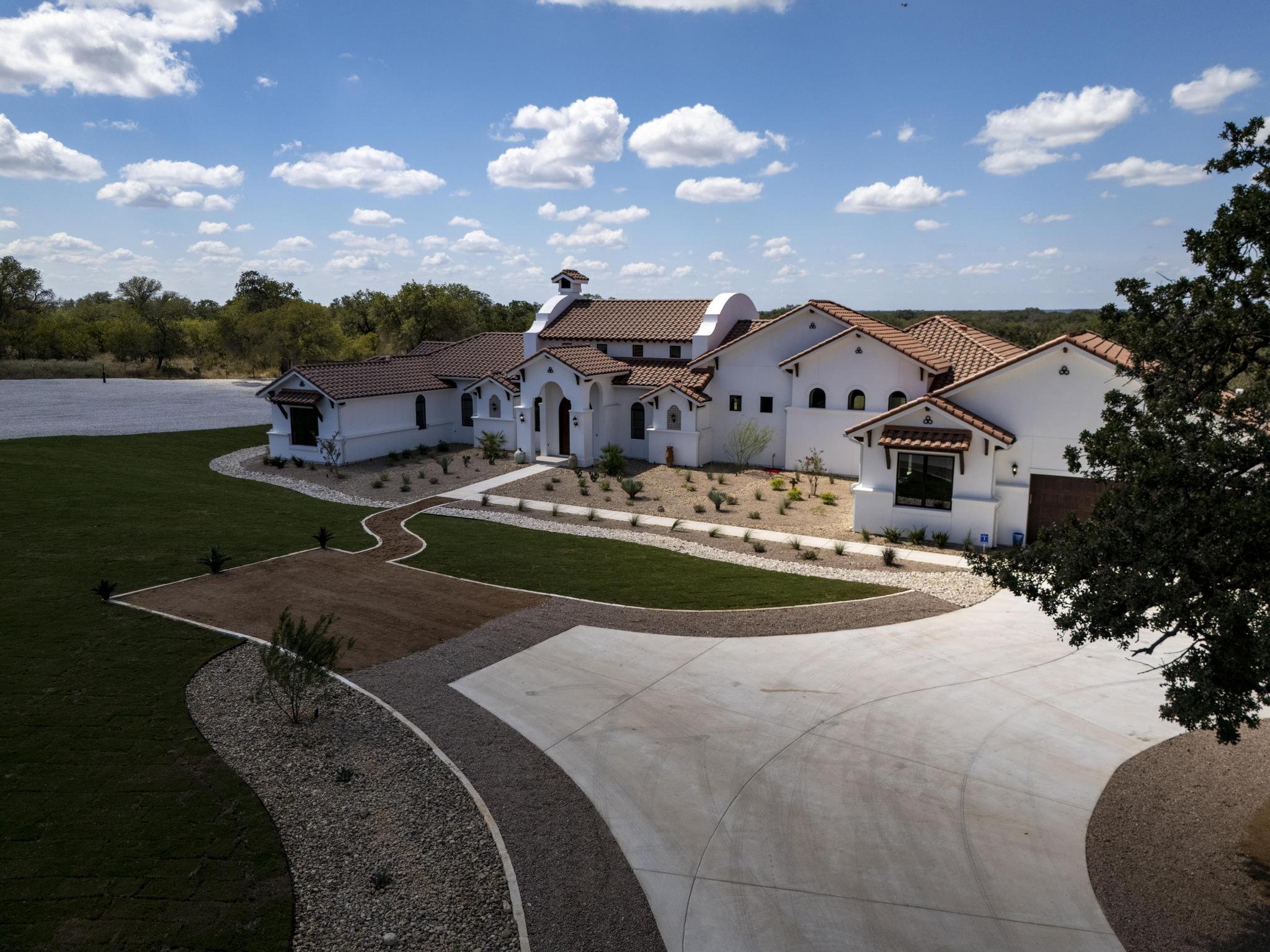 A sweeping aerial of a Marquis Builders custom home in the Texas Hill Country