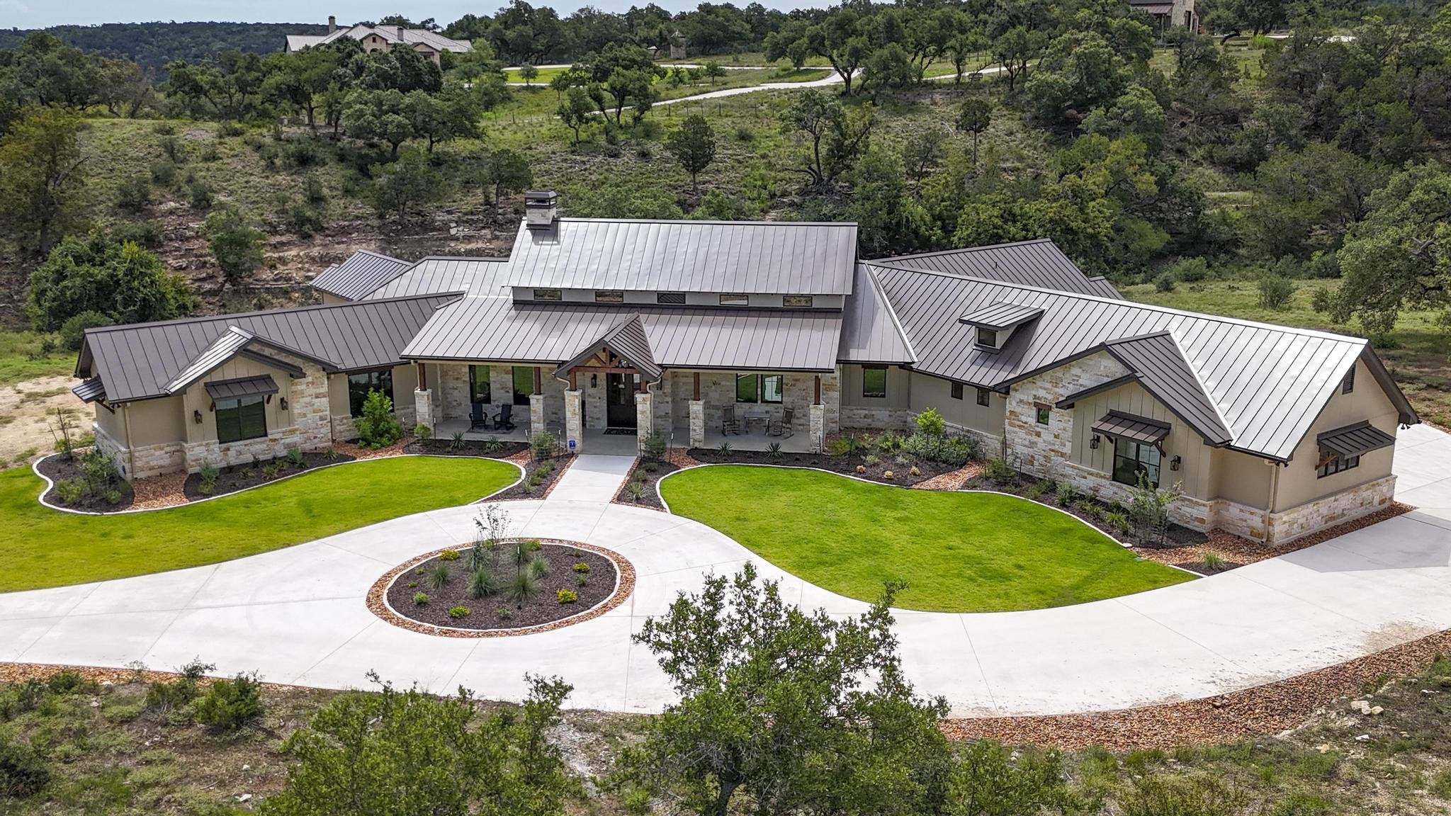 A Marquis Builders custom home set in its Hill Country surroundings, aerial view