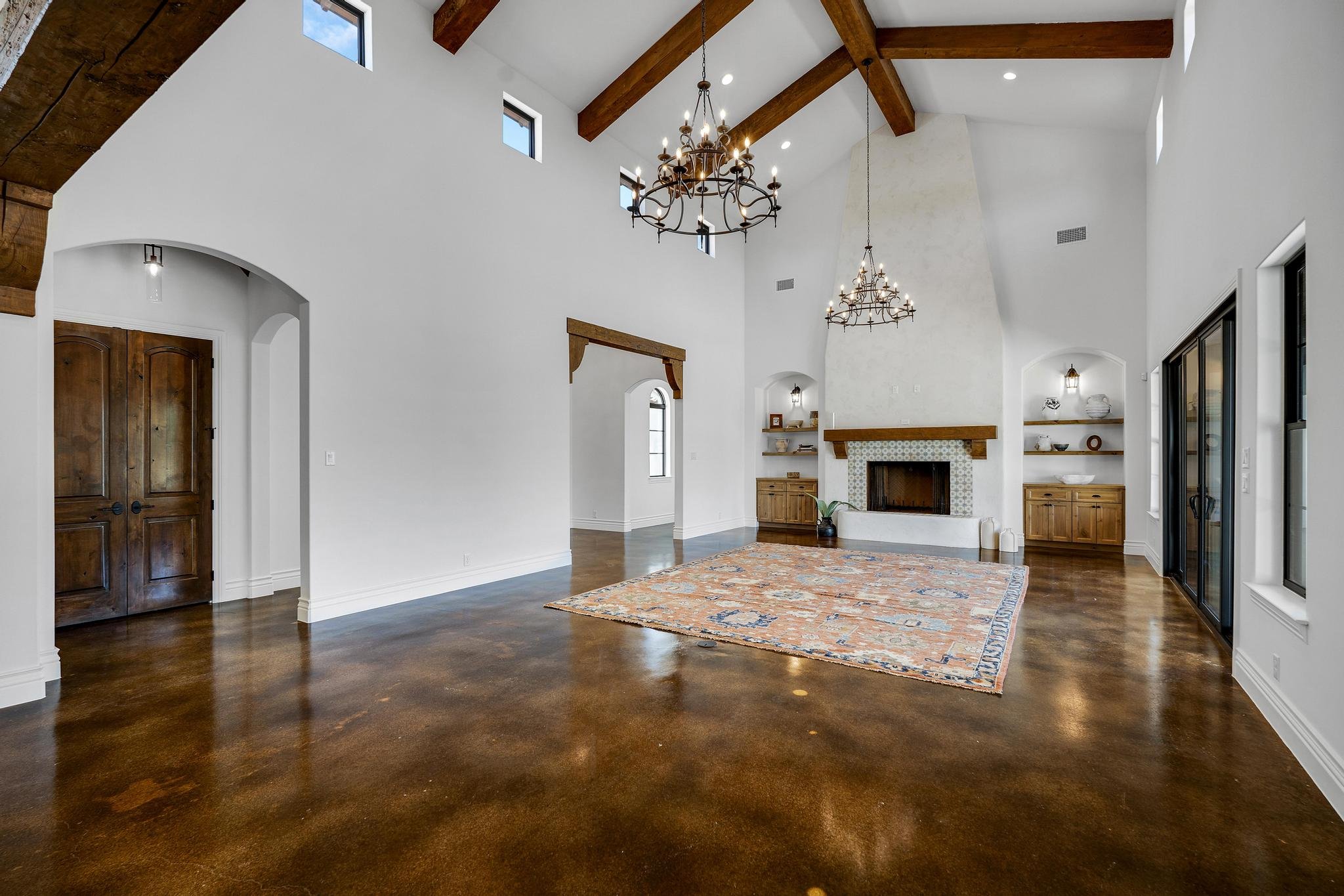 Living room with a stone fireplace and beamed ceiling in a Marquis Builders home